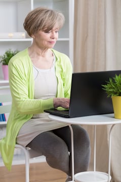 Attractive mature woman dating online on laptop