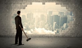 Business man hitting wall with hammer on city view background-1
