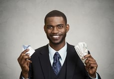 Closeup portrait happy, smiling business man company employee standing, holding dollar bills, credit card hand isolated grey black background. Banking exchange rate concept. Facial expression reaction-1