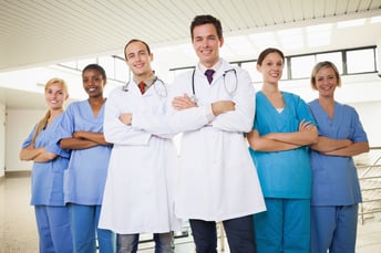 Doctors with nurses with arms crossed in hospital corridor