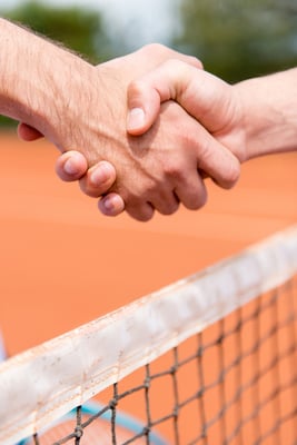 Handshake at a tennis match over the net