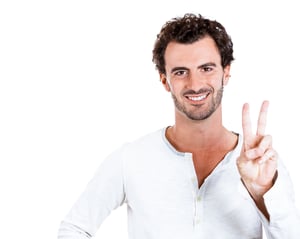 Closeup portrait of happy, excited successful young man giving peace, victory or two sign, isolated on white background. Positive emotions, face expressions, feelings, attitude, reaction, perception