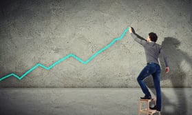 Young man drawing a financial graph on the wall