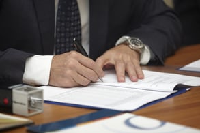 close up of businessman hands signing contract